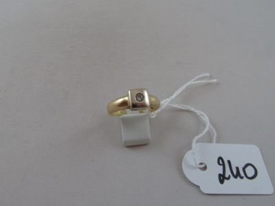 a gold ring with a diamond on it and a white tag
