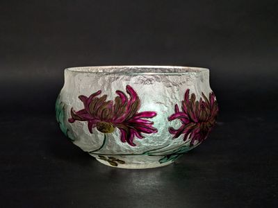 un bol blanc orné de fleurs violettes, posé sur une table