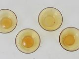 four eggs are sitting in small bowls on a white surface