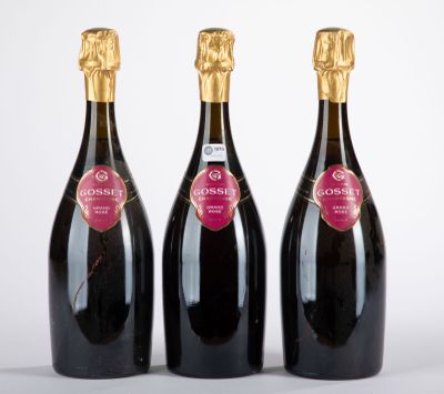 trois bouteilles de champagne posées les unes à côté des autres sur une surface blanche