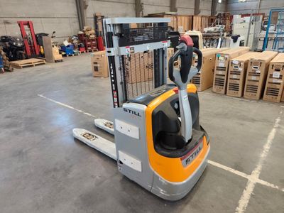 a forklift in a warehouse with boxes and pallets in the background