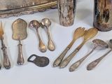 a lot of silverware on a table with a silver tray