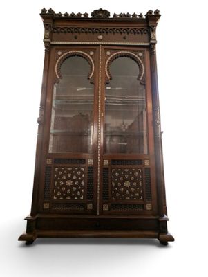 an antique wooden display cabinet with glass doors and ornate carvings
