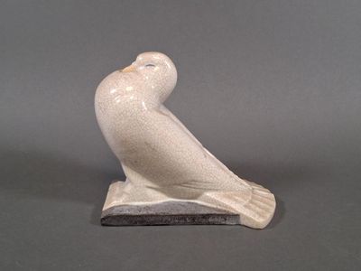 statue of a bird sitting on a base on a gray surface