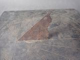 a sundial on a table with a clock on it