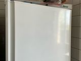 a white refrigerator in the corner of a kitchen