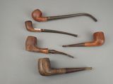Quatre pipes sont alignées sur une table : il y en a une au milieu et une autre au milieu.