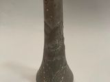 a close up of a vase on a table with a white background