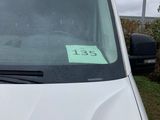 a white van with a green sticker on the windshield