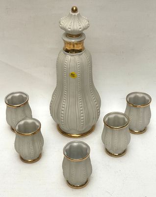 five cups and a decanter sitting on a table
