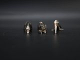 three silver shoes sitting next to each other on a black surface