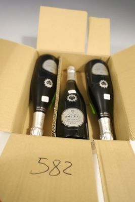 trois bouteilles de champagne dans un coffret avec une étiquette de prix