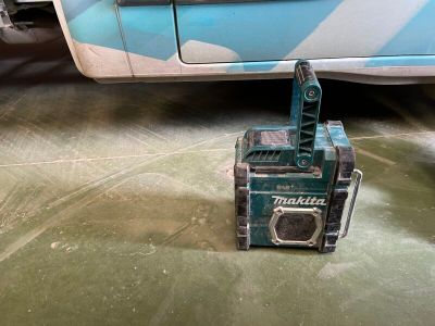 une petite machine posée par terre à côté d'une voiture