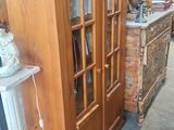deux photos d'une armoire en bois avec des portes vitrées