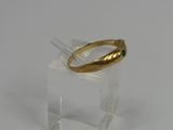 a gold ring with a green stone on top of it