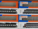 Six trains miniatures sont rangés dans une boîte posée sur une table