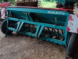 une photo d'un tracteur avec une remorque dans une grange