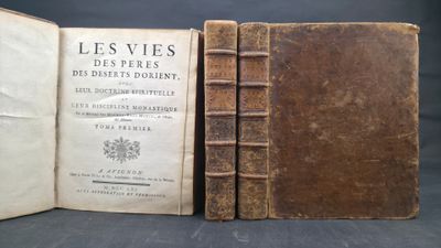 an old book sitting open on top of a table next to another book