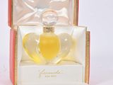 an open box with a perfume bottle inside of it on a white surface