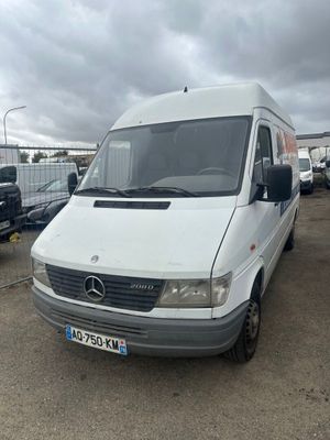 la camionnette blanche est garée dans un parking avec d'autres voitures
