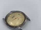 a silver and gold watch on a white surface