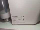 a white microwave sitting on a shelf next to a bottle of water