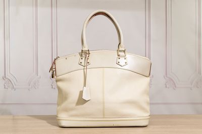 un sac à main blanc posé sur une table devant un mur