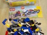a pile of legos sitting on a table next to a box of legos