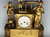 une horloge en or surmontée d'une statue