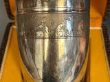 a silver cup sitting in a yellow box on a table