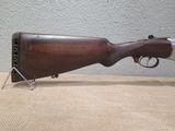 a close up of a rifle on a table with a wall in the background