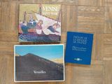 deux livres posés sur un plancher en bois, à côté d'un livre bleu