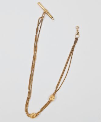 un gros plan d'un collier en or orné d'une barre