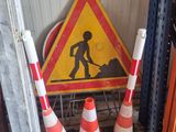 une pile de cônes de signalisation et un panneau routier dans un garage