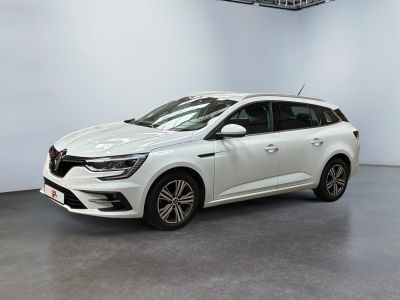 Une voiture blanche est garée dans une pièce blanche au sol noir.