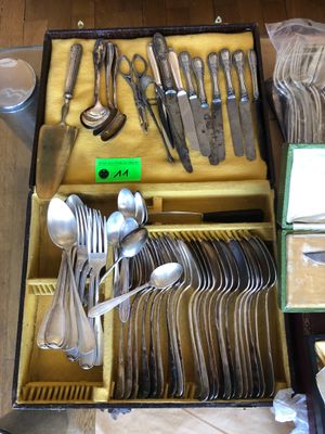 beaucoup d'argenterie dans un coffret posé par terre