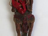 une vieille sculpture en bois représentant un homme coiffé d'un chapeau