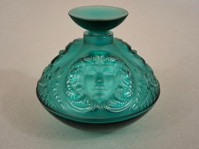 a green glass vase with a face on it