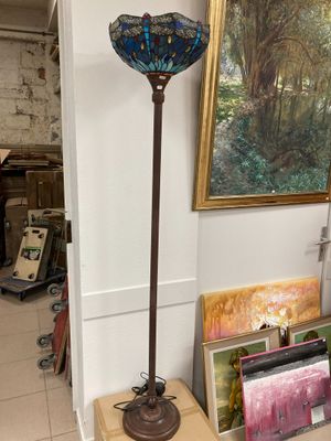 a lamp that is sitting on a table next to a painting