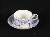 une petite tasse et une soucoupe posées sur une table noire