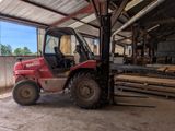 un chariot élévateur rouge garé dans un entrepôt