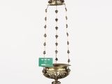 an old brass hanging candle holder with a green tag on it