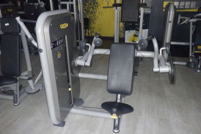 un ensemble d'appareils de musculation installé dans une pièce aux murs jaunes