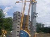 une grue posée au sommet d'un tas de parpaings