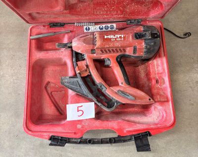 une boîte à outils rouge contenant un marteau et d'autres outils