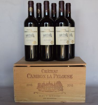 four bottles of wine sit in a wooden box on a table