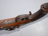 an old gun with a wooden handle on a white surface
