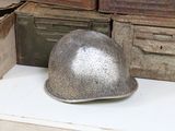 a helmet sitting on top of a table next to old boxes