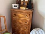 a dresser with a mirror and a chair in a room
