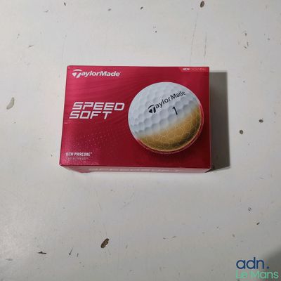 La boîte de balles de golf est posée sur la table, prête à être rangée.